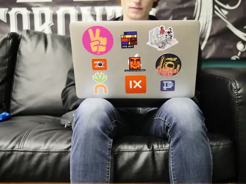 Man working on a laptop with stickers
